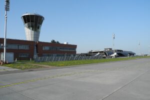 Řídicí věž a terminál Letiště Brno-Tuřany s odbavovací plochou za slunečného dne