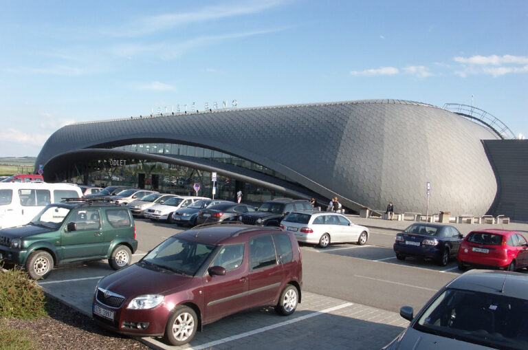 Parkoviště před terminálem Letiště Brno-Tuřany s charakteristickou zvlněnou střechou budovy